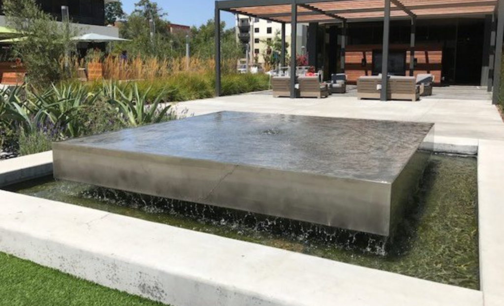 Tranquil fountain amid lush greenery.