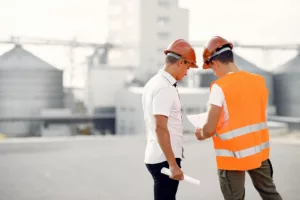 Еngineers in a halmet standing by the factory